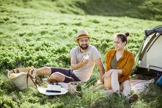 couple-having-a-picnic-near-the-tent-in-the-mountain